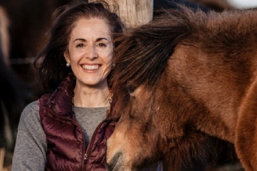 Mujer sonriente con un caballo